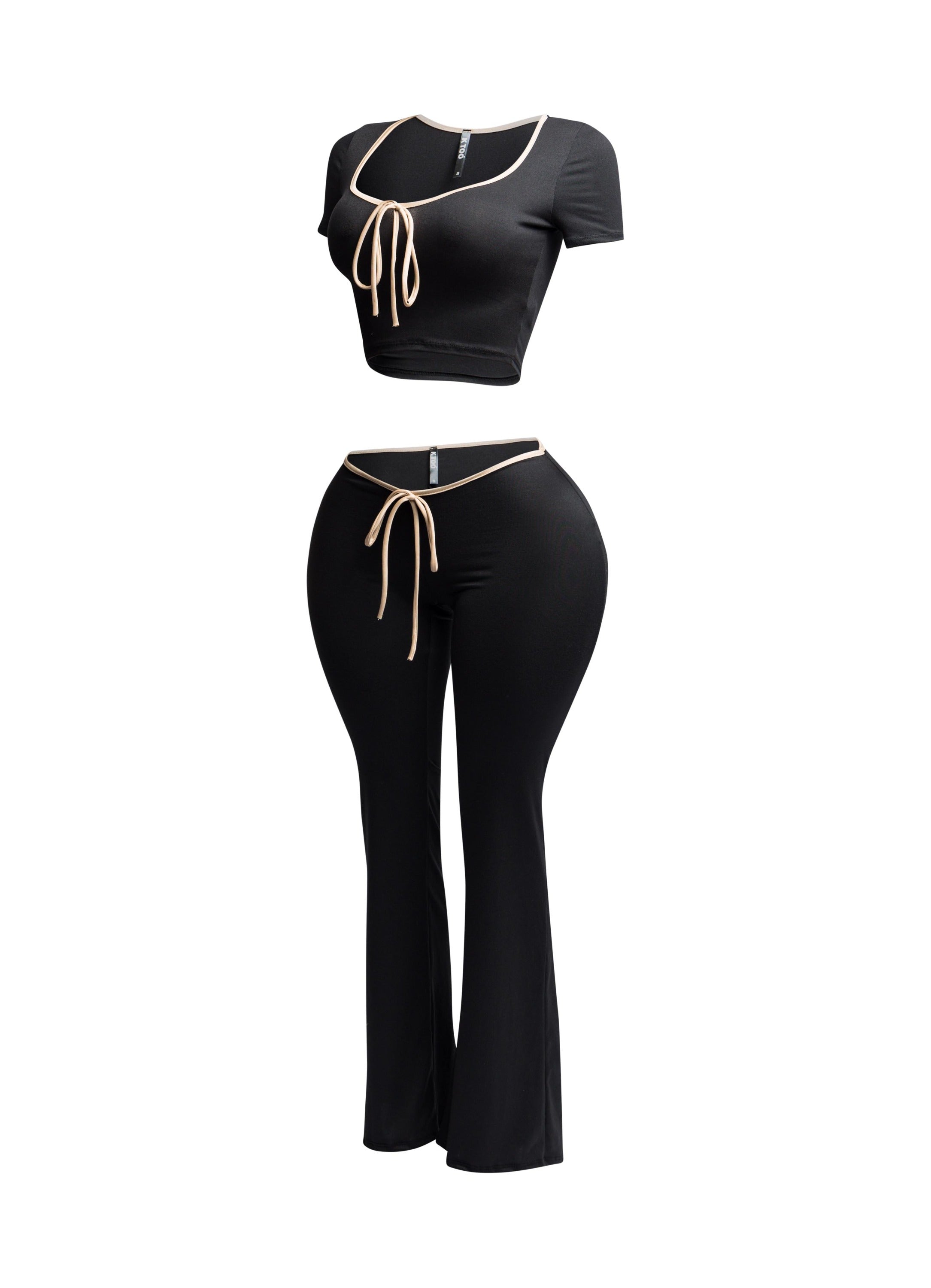 Side view of black and nude trim two-piece set with a tie-front crop top and high-waisted flared pants.