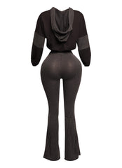 Elegant black two-piece set with a cropped pullover hoodie and figure-hugging high-waisted flared pants, crafted with a ribbed texture for a stylish and sophisticated outfit.